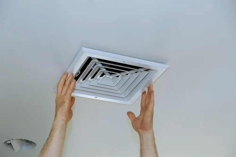 Strickland's Gold IAQ Options Package - Close up man hand installing vent cover.