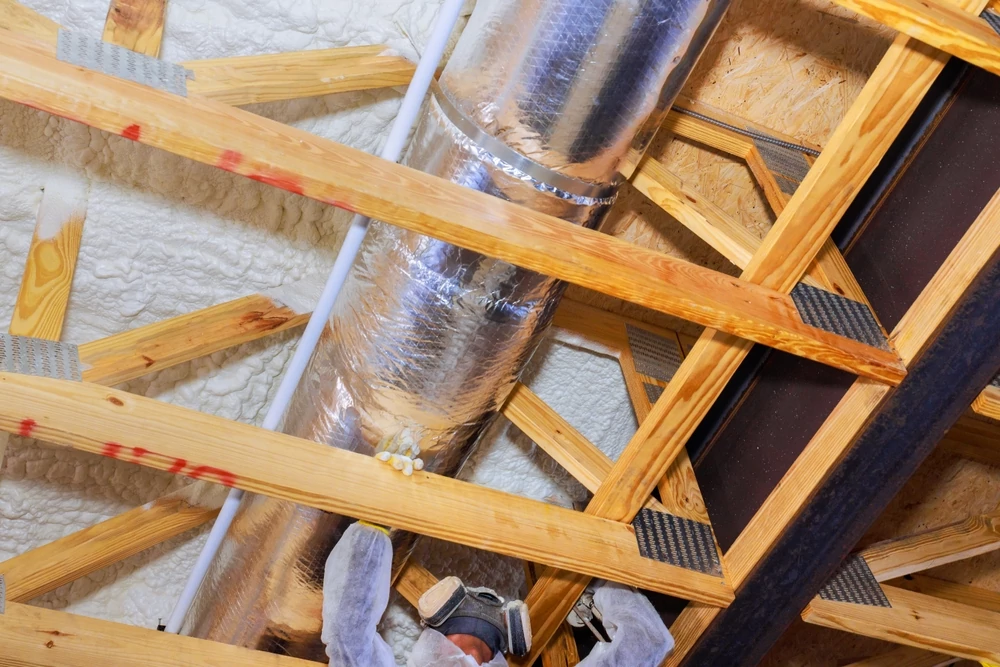 HVAC worker insulating ducts
